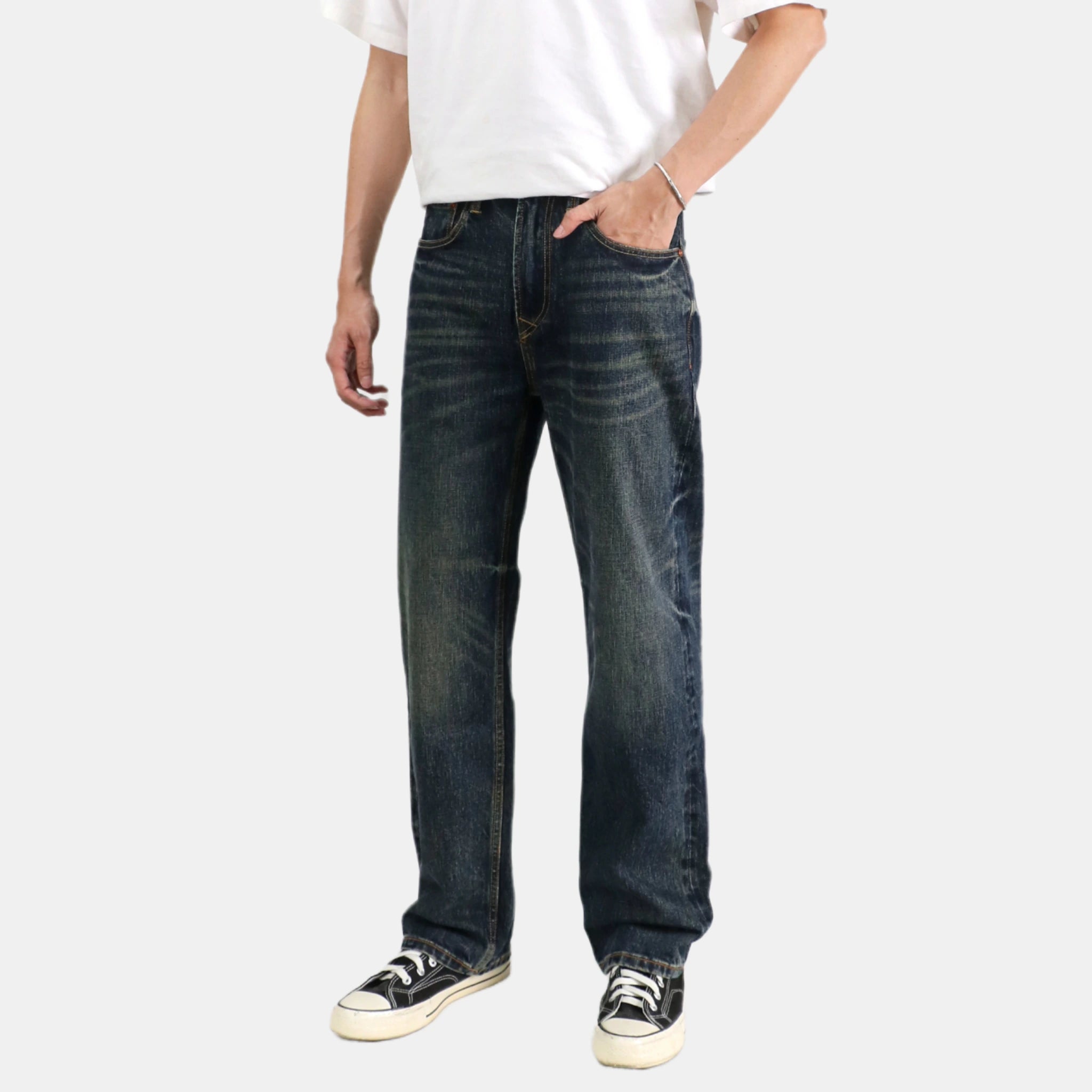 Person wearing dark blue jeans and a white shirt on a white background