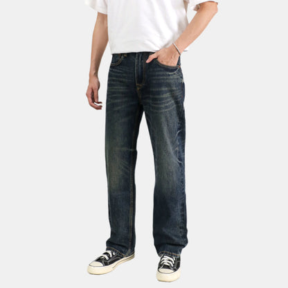 Person wearing dark blue jeans and a white shirt on a white background