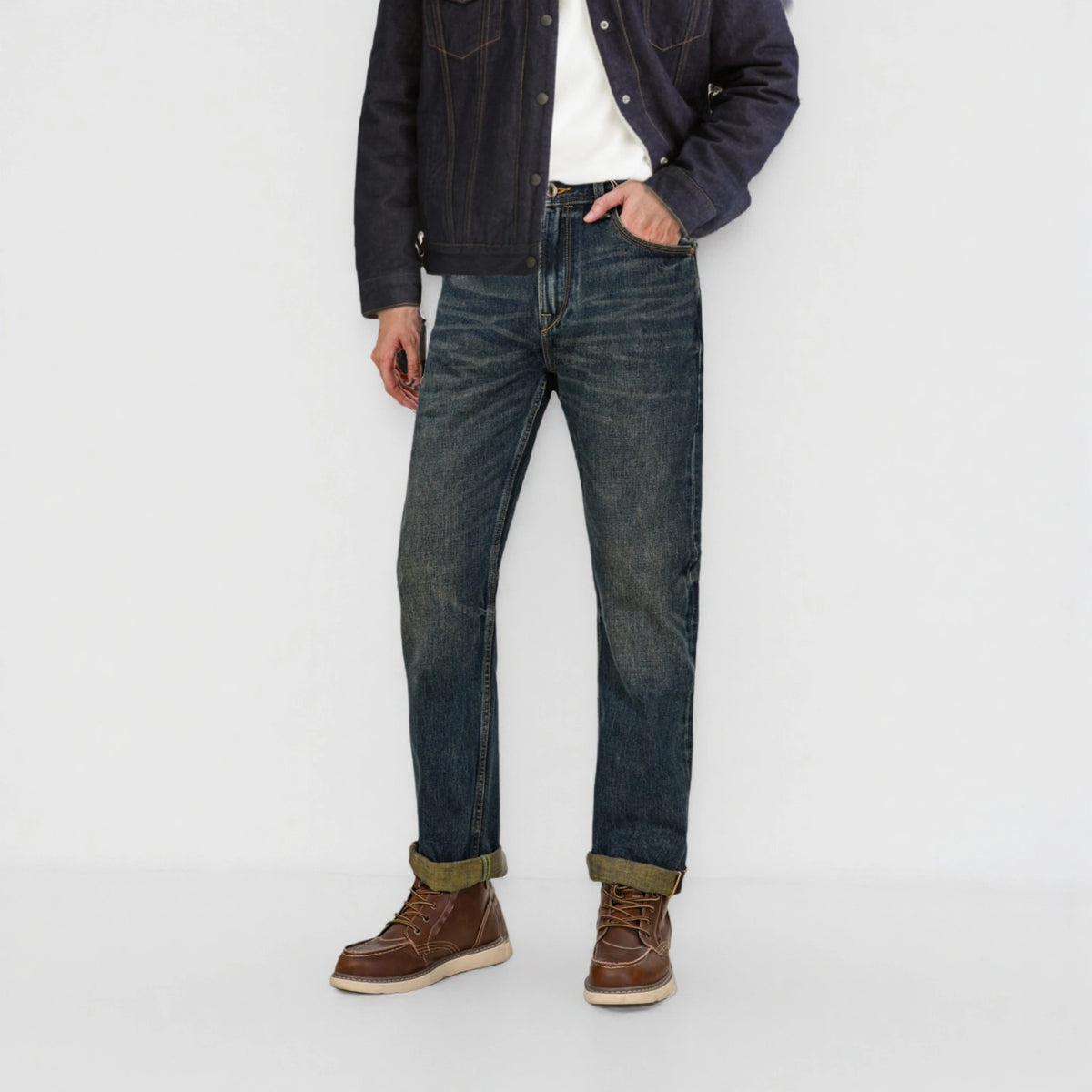 Person wearing dark blue jeans and a denim jacket on a white background