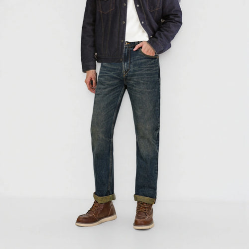 Person wearing dark blue jeans and a denim jacket on a white background