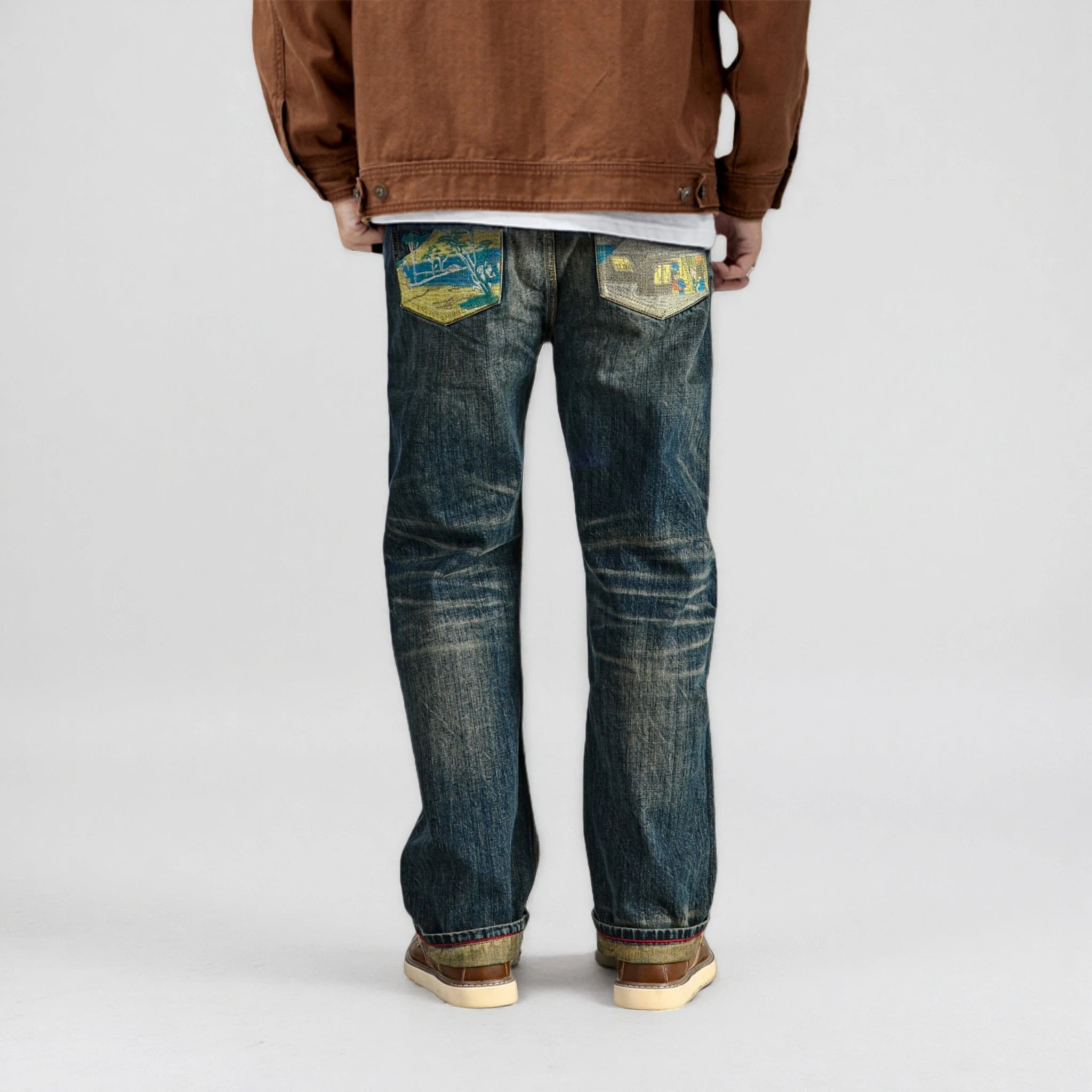 Person wearing blue jeans with patches on a white background