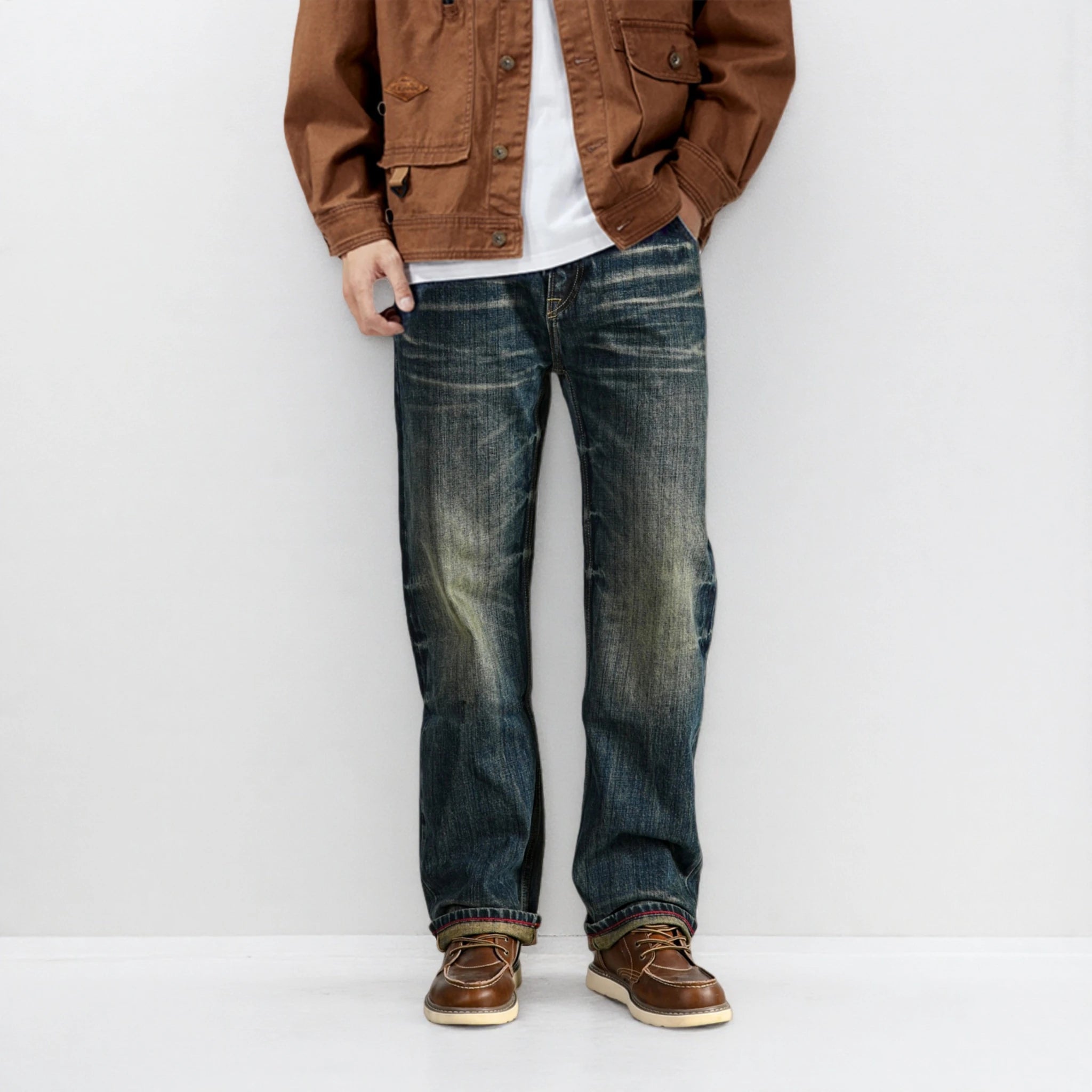Person wearing a brown jacket, white shirt, blue jeans, and brown shoes against a white background