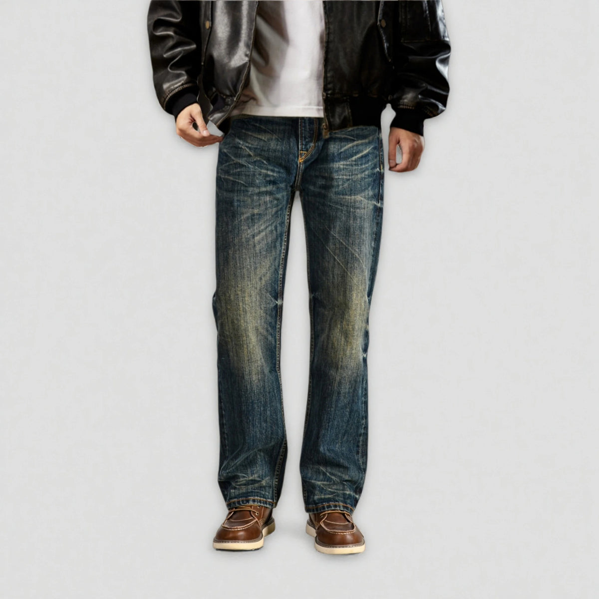 Person wearing blue jeans and a black jacket on a plain background