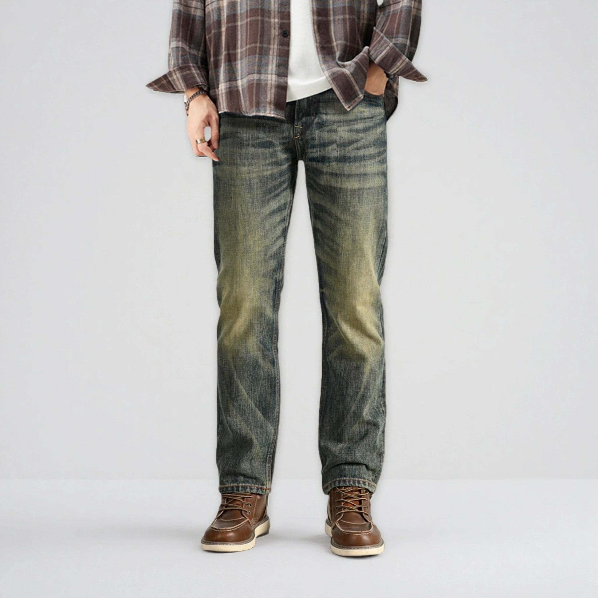 Person wearing plaid shirt, white t-shirt, jeans, and brown shoes on a light gray background