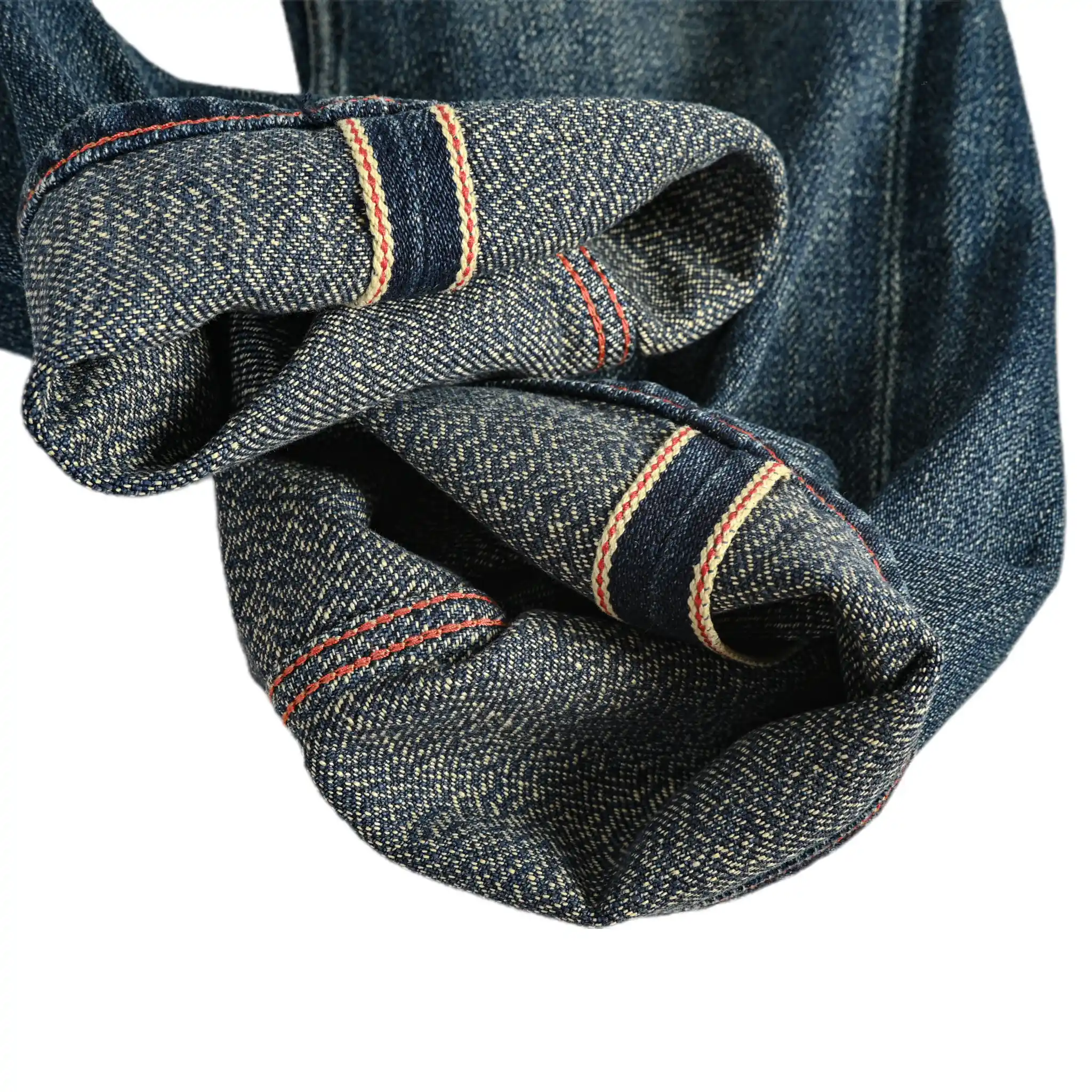 Close-up of blue denim fabric with visible stitching on a white background
