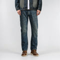 Person wearing blue jeans and a denim jacket on a white background