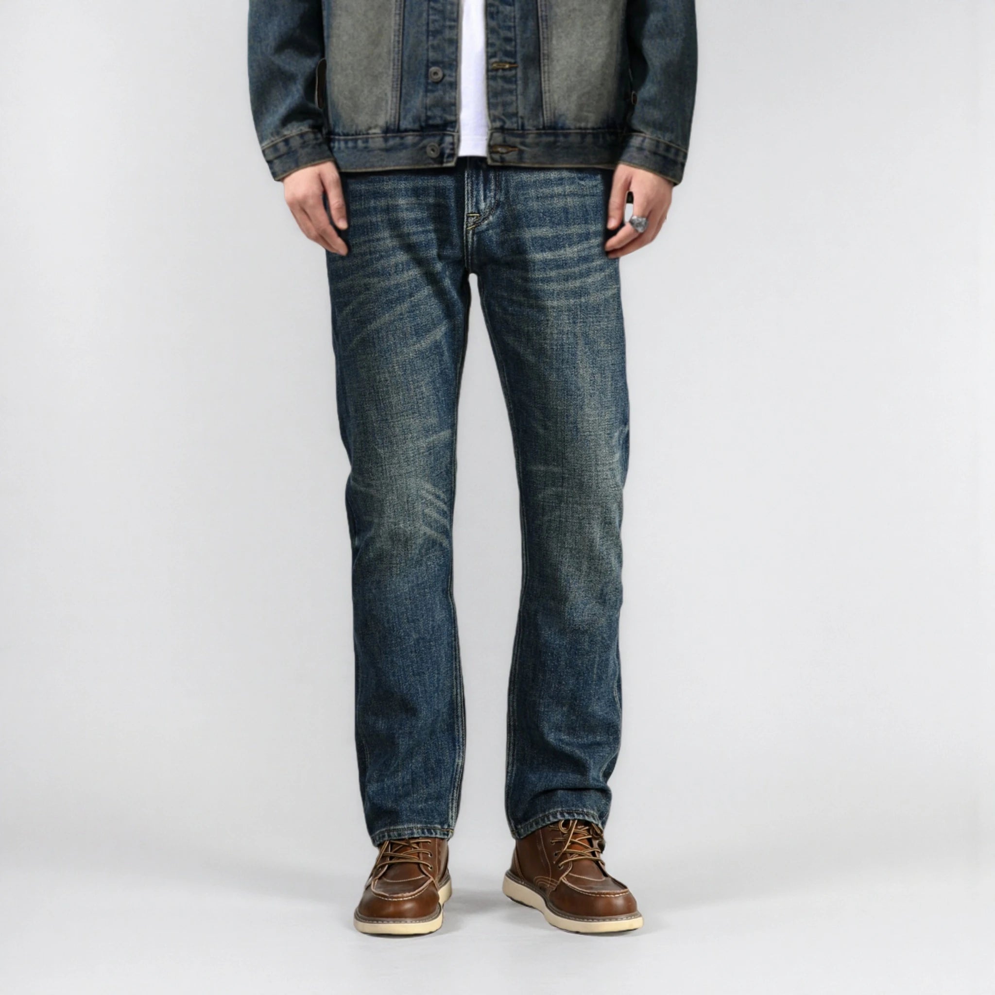 Person wearing blue jeans and a denim jacket on a white background