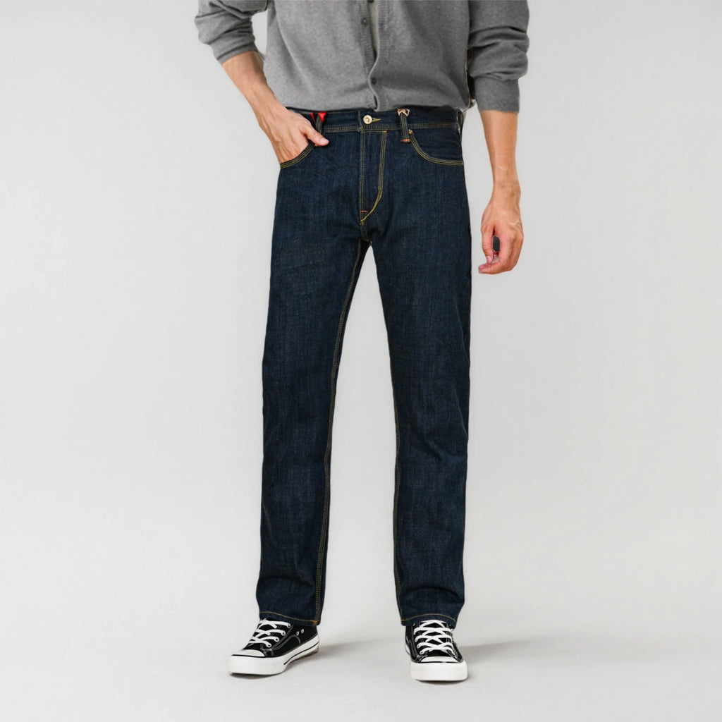 Person wearing dark blue jeans and a gray shirt on a white background