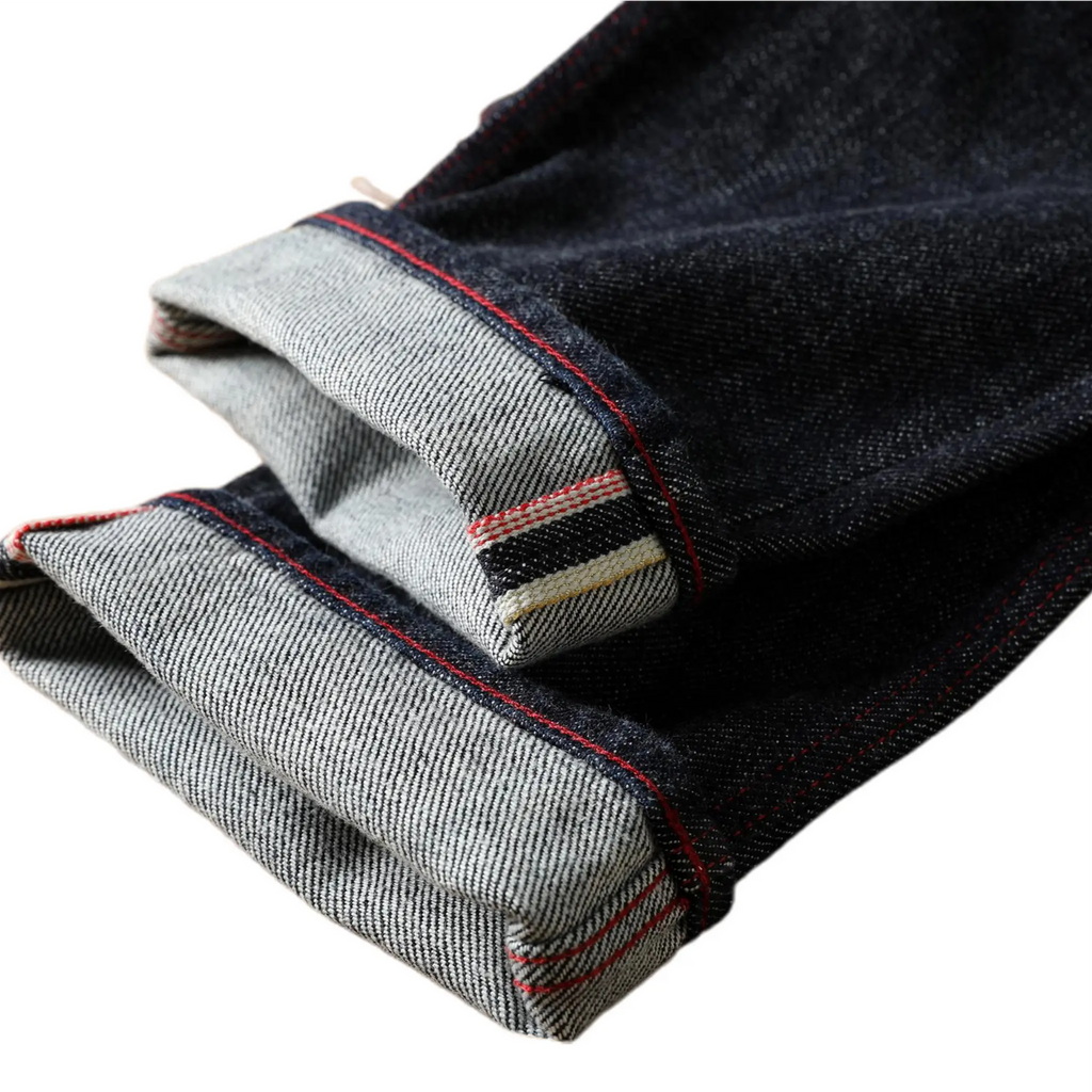 Folded denim jeans with visible stitching on a white background