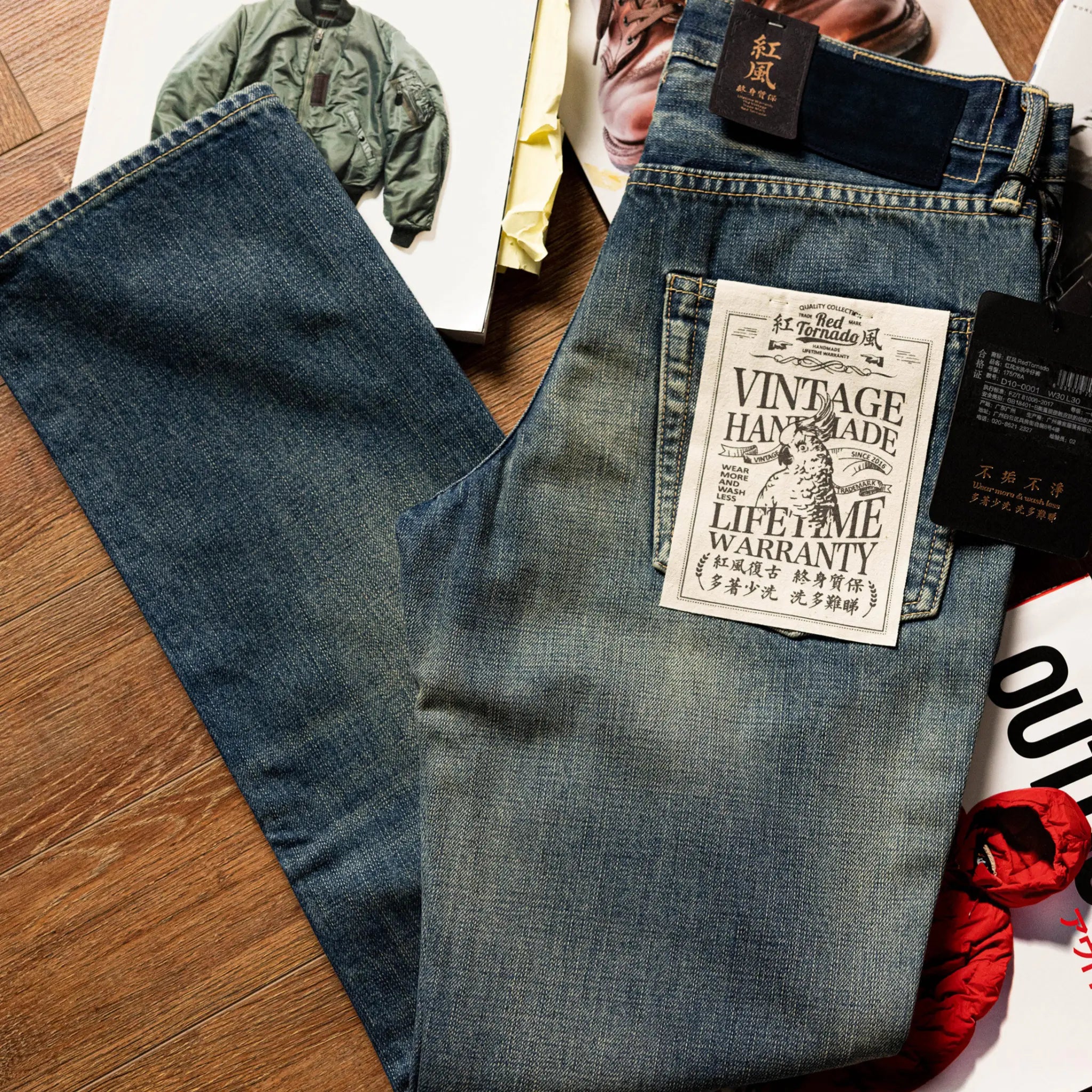 Pair of blue jeans with a vintage-style warranty tag on a wooden surface.