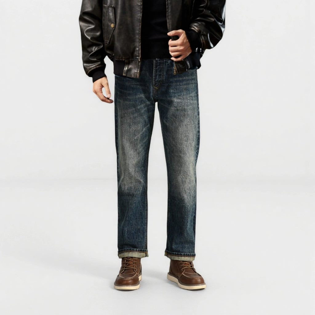 Person wearing dark jeans and a leather jacket on a white background