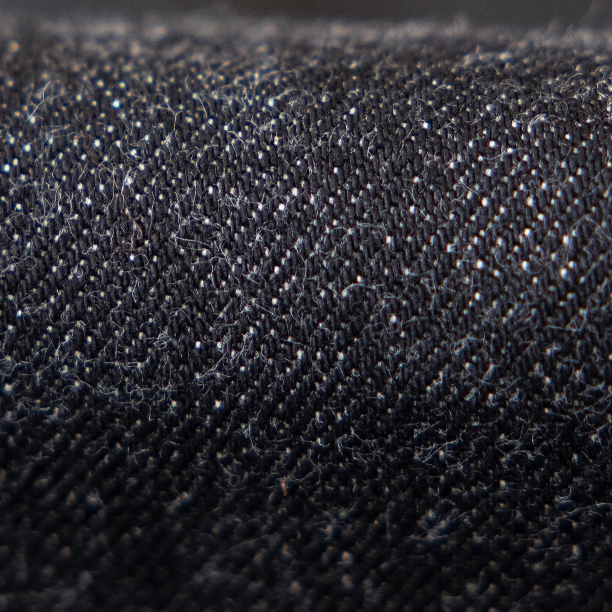 Close-up of the material texture on 14.5oz Sulfur Black Selvedge Denim Jeans Straight Fit