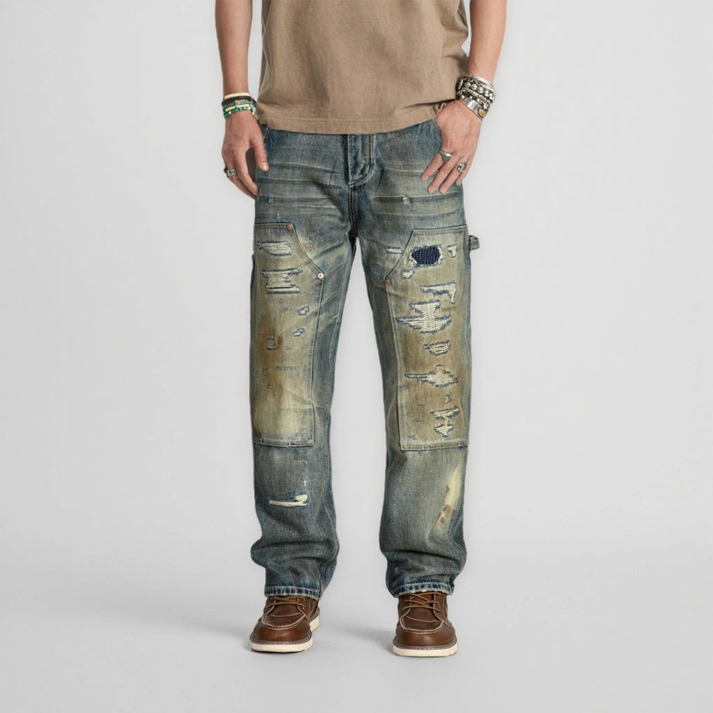 Person wearing distressed blue jeans on a plain background