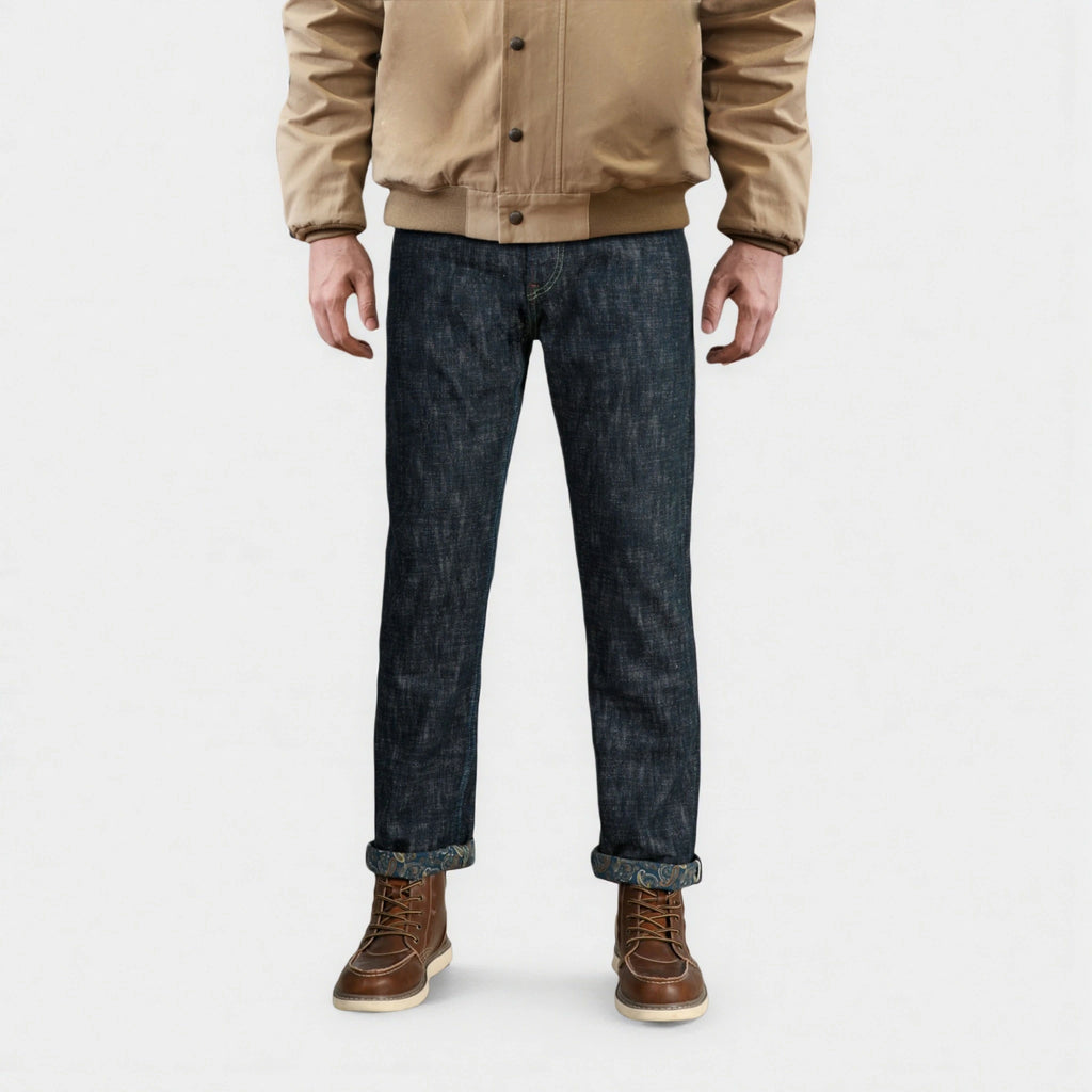 Person wearing a beige jacket, dark jeans, and brown boots on a white background