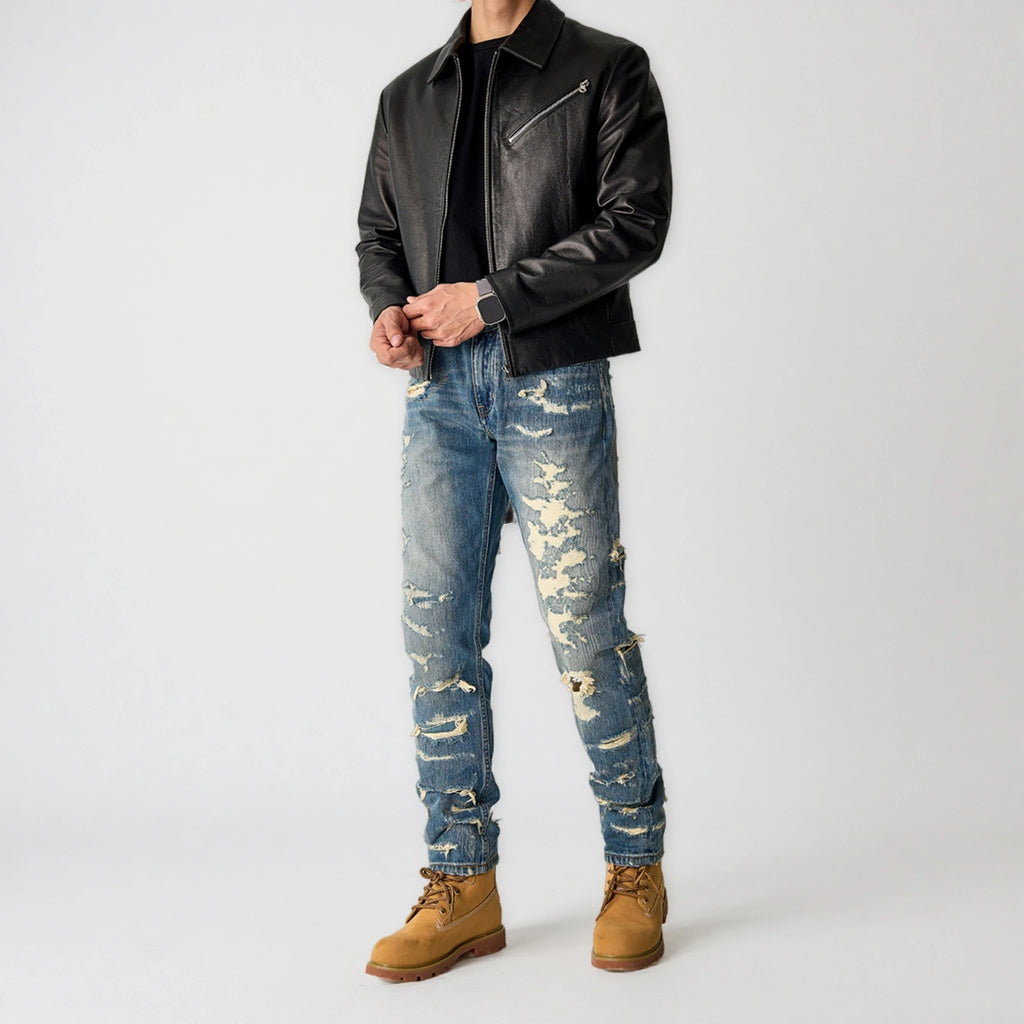Person wearing a black leather jacket, distressed blue jeans, and brown boots on a white background